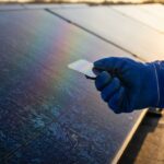 Perowskit-Silizium-Tandemsolarzelle: Laborzelle vor einer Photovoltaik-Dachanlage im Abendlicht